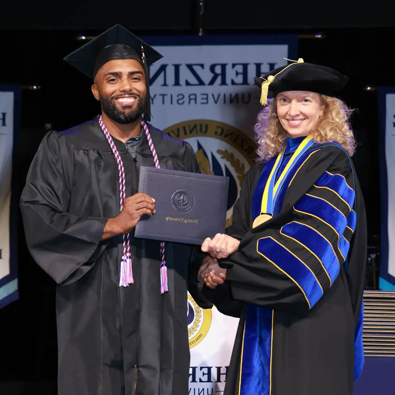 Herzing graduate receiving his diploma from University President.