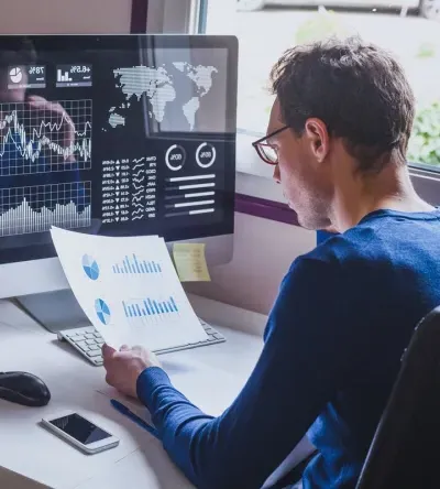 Data Analyst Reviewing Analytics Report at Computer