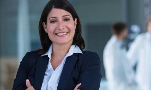 Nurse Leader with Healthcare Administrators in Meeting in Background 